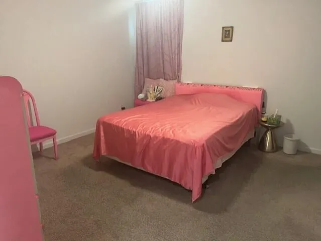 a bedroom with a bed and a potted plant