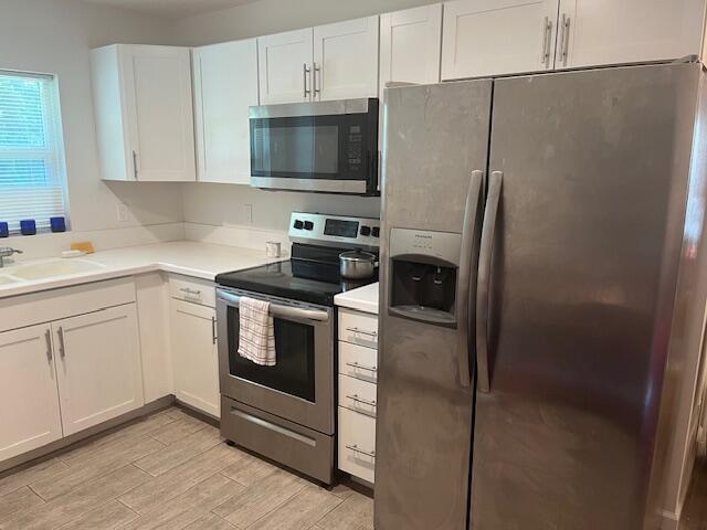 3665 Southeast Lower Street Stuart, FL 34997 - Photo 19 of 20 a kitchen with a refrigerator stove and white cabinets