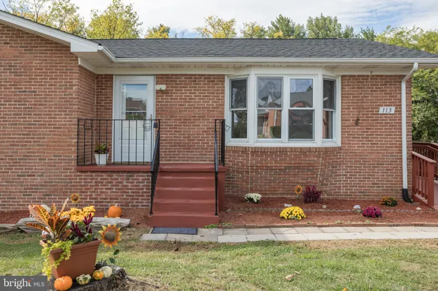 a view of a house with wooden deck and a yard