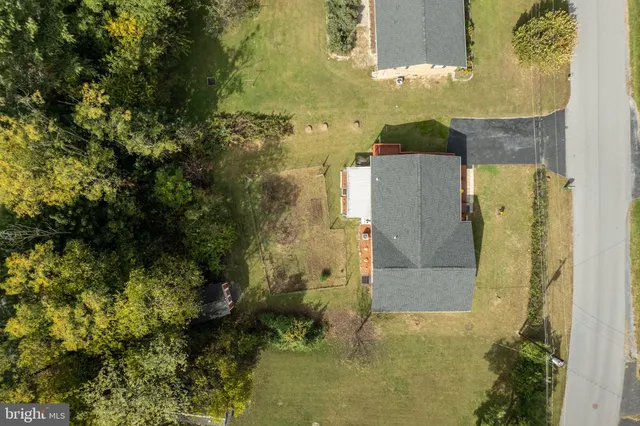 an aerial view of a house with a yard swimming pool and outdoor seating