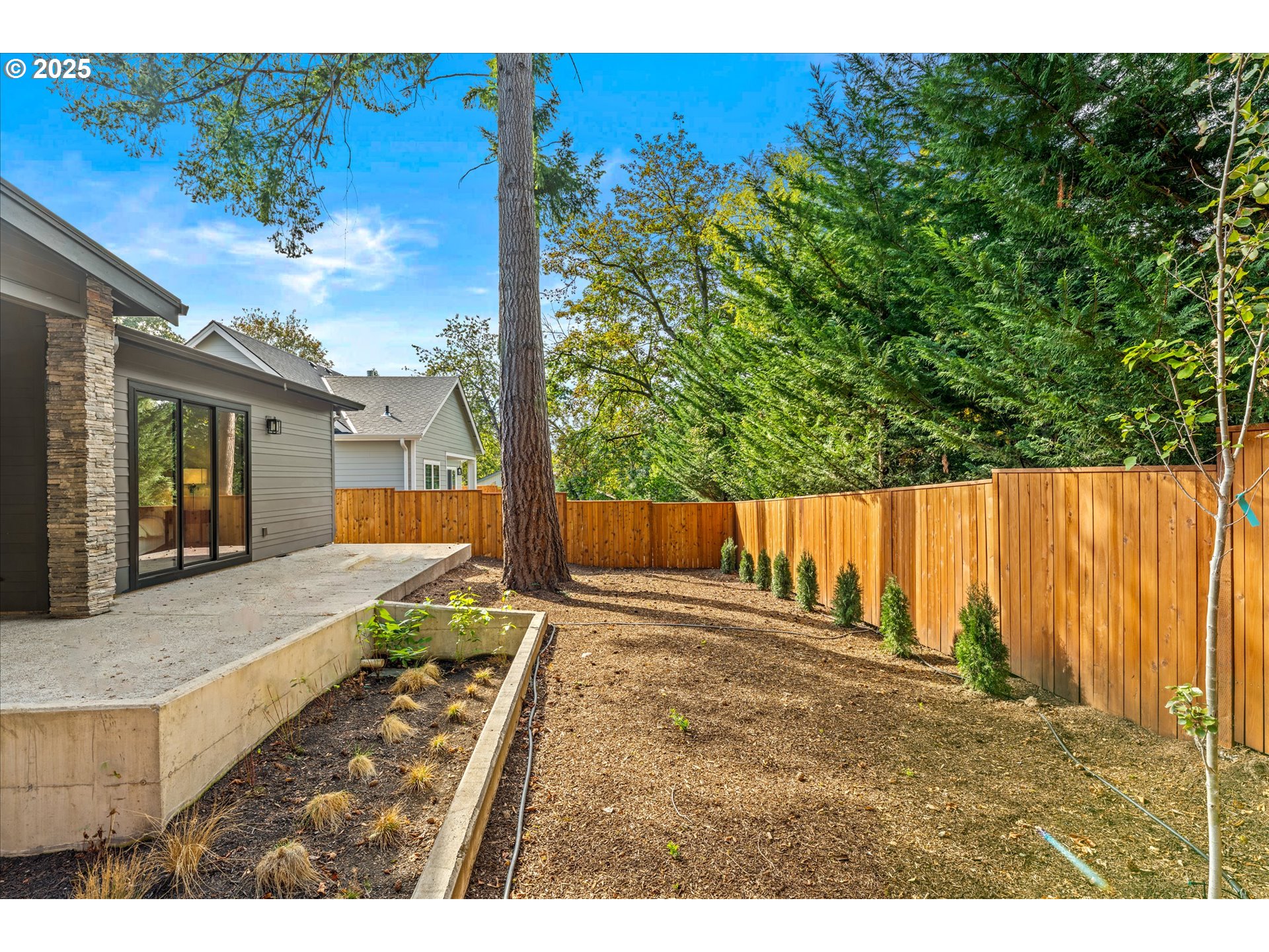 15003 Twin Fir Road Lake Oswego, OR 97035 - Photo 39 of 42 a view of a backyard with plants and wooden fence
