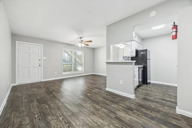 a view of a kitchen with wooden floor and a window