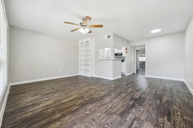 a view of a kitchen with a sink and dishwasher a refrigerator with wooden floor
