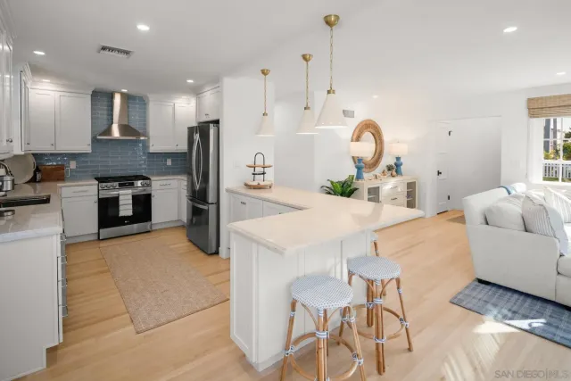 a kitchen with stainless steel appliances kitchen island granite countertop a table chairs and a refrigerator
