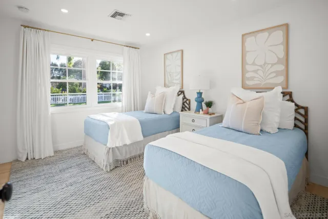 a bedroom with two beds and a large window