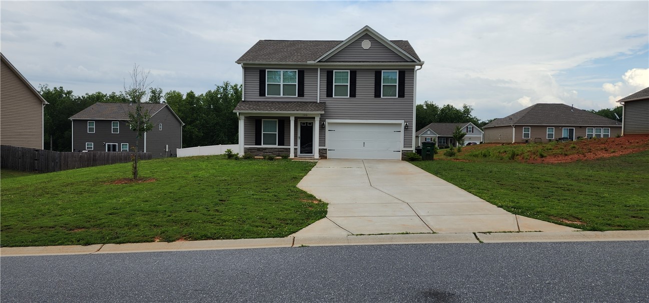 140 Sunny Point Loop Central, SC 29630 - Photo 1 of 31 A classic two-story residence with a welcoming front porch and a wide concrete driveway leading to an attached garage.
