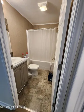 a bathroom with a sink a toilet a mirror and a shower
