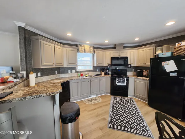 a kitchen with a table chairs a sink dishwasher and cabinets