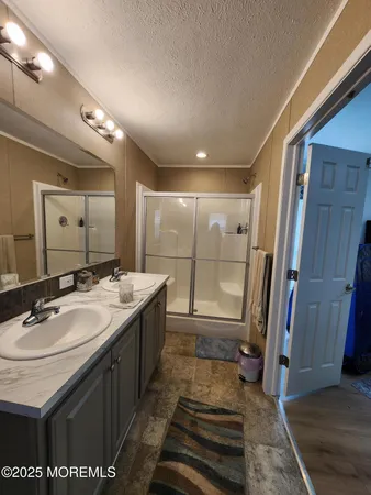 a bathroom with a sink a mirror and a shower
