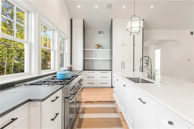 a kitchen with stainless steel appliances a stove a sink and cabinets