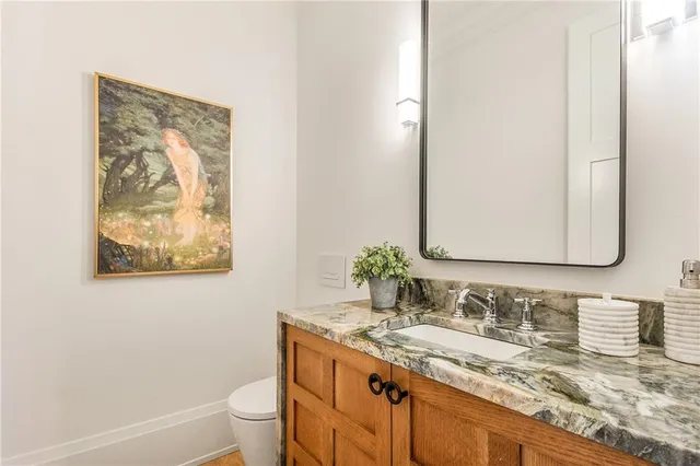 a bathroom with a granite countertop sink a toilet and a mirror