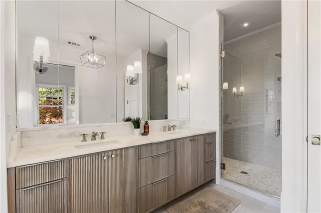 a bathroom with a double vanity sink mirror and shower