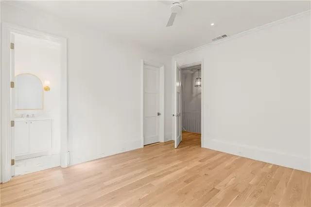 an empty room with wooden floor and mirror