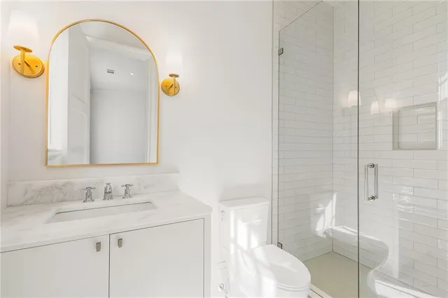 a bathroom with a granite countertop sink a toilet and shower