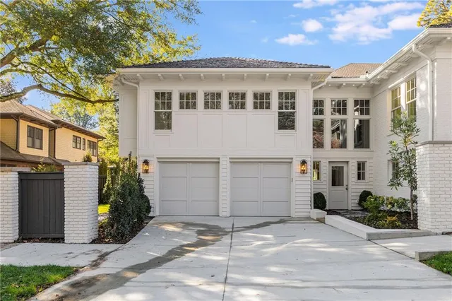 a view of a white building among the street with palm trees