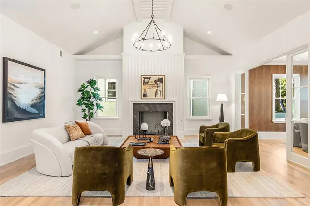 a living room with furniture a fireplace and a chandelier