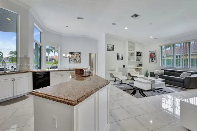 a kitchen with stainless steel appliances granite countertop a refrigerator a sink a stove and white cabinets