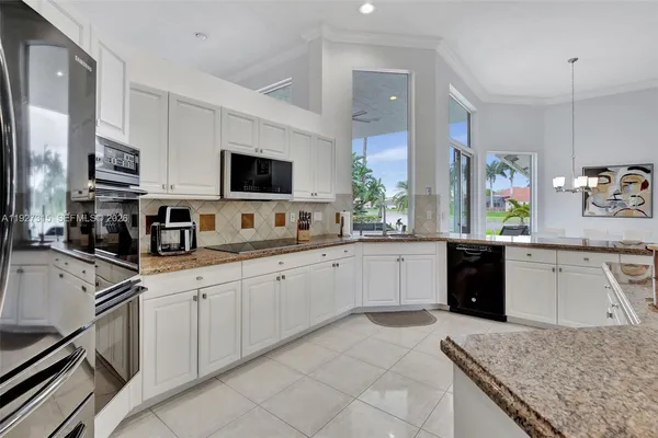a kitchen with stainless steel appliances granite countertop a sink dishwasher stove top oven and refrigerator