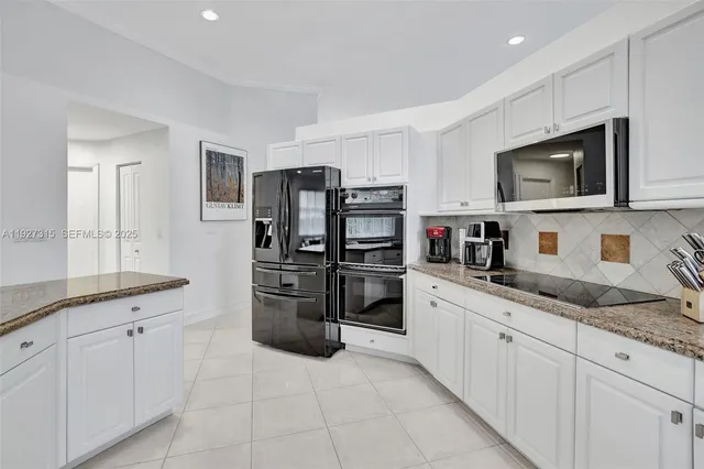 a kitchen with stainless steel appliances granite countertop a sink dishwasher stove top oven and refrigerator