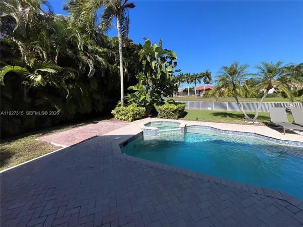 a view of a backyard with a garden and palm trees