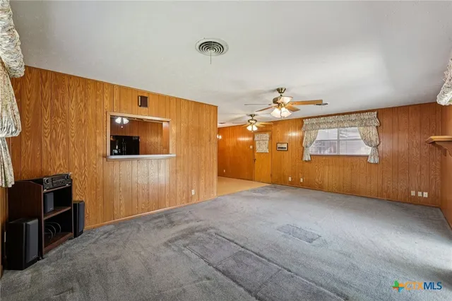 an empty room with windows and cabinet