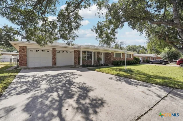 a view of house with backyard and tree
