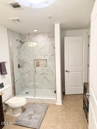 a bathroom with a toilet and a shower