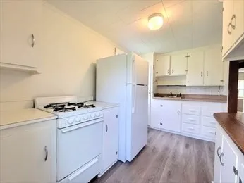 a kitchen with granite countertop cabinets stainless steel appliances and wooden floor