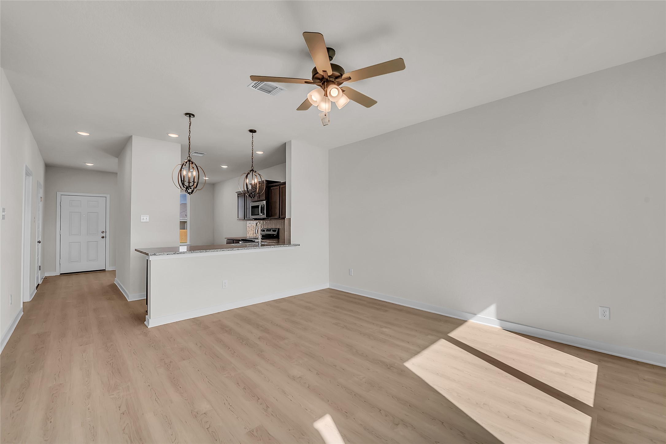 308 Boatright Boulevard Jarrell, TX 76537 - Photo 18 of 31 Unfurnished living room with light wood-type flooring, recessed lighting, a chandelier, and ceiling fan