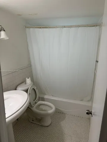 a bathroom with a toilet a sink and bathtub