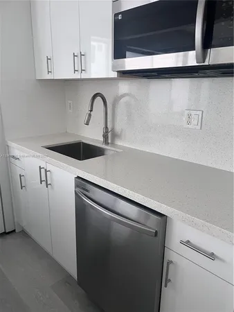 a close view of a sink and cabinets in the kitchen