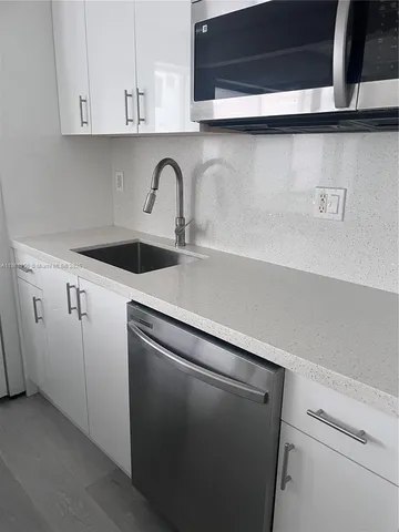a close view of a sink and cabinets in the kitchen