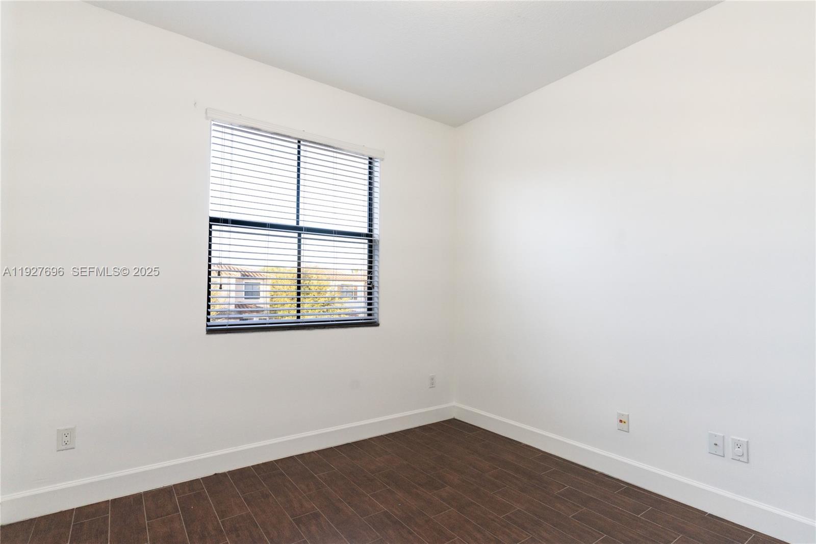 4638 Northwest 59th Street Tamarac, FL 33319 - Photo 14 of 34 an empty room with wooden floor and windows