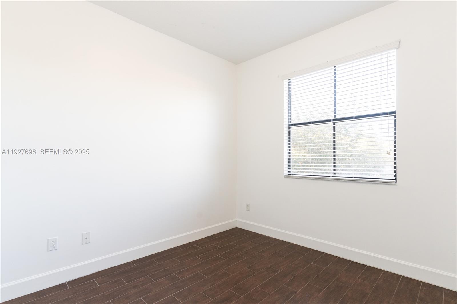 4638 Northwest 59th Street Tamarac, FL 33319 - Photo 15 of 34 an empty room with wooden floor and windows