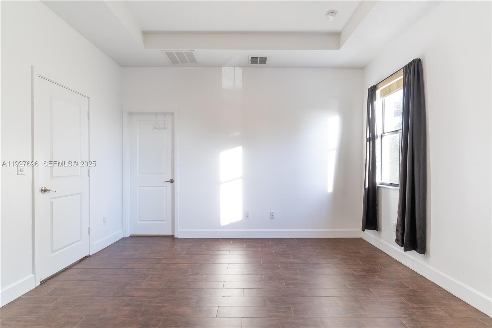 4638 Northwest 59th Street Tamarac, FL 33319 - Photo 19 of 34 an empty room with wooden floor and windows
