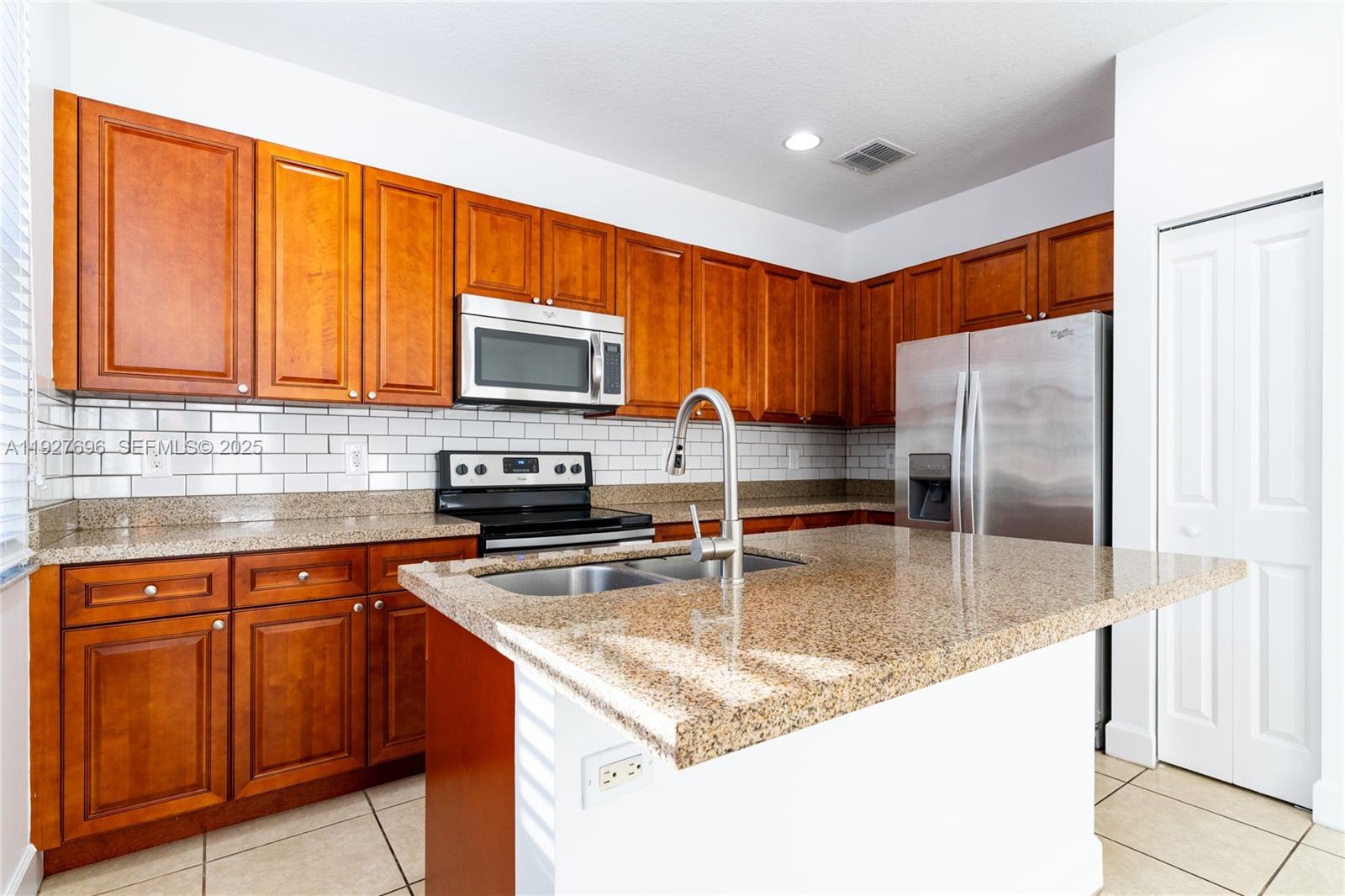 4638 Northwest 59th Street Tamarac, FL 33319 - Photo 2 of 34 a kitchen with stainless steel appliances granite countertop a refrigerator a stove top oven a sink and dishwasher