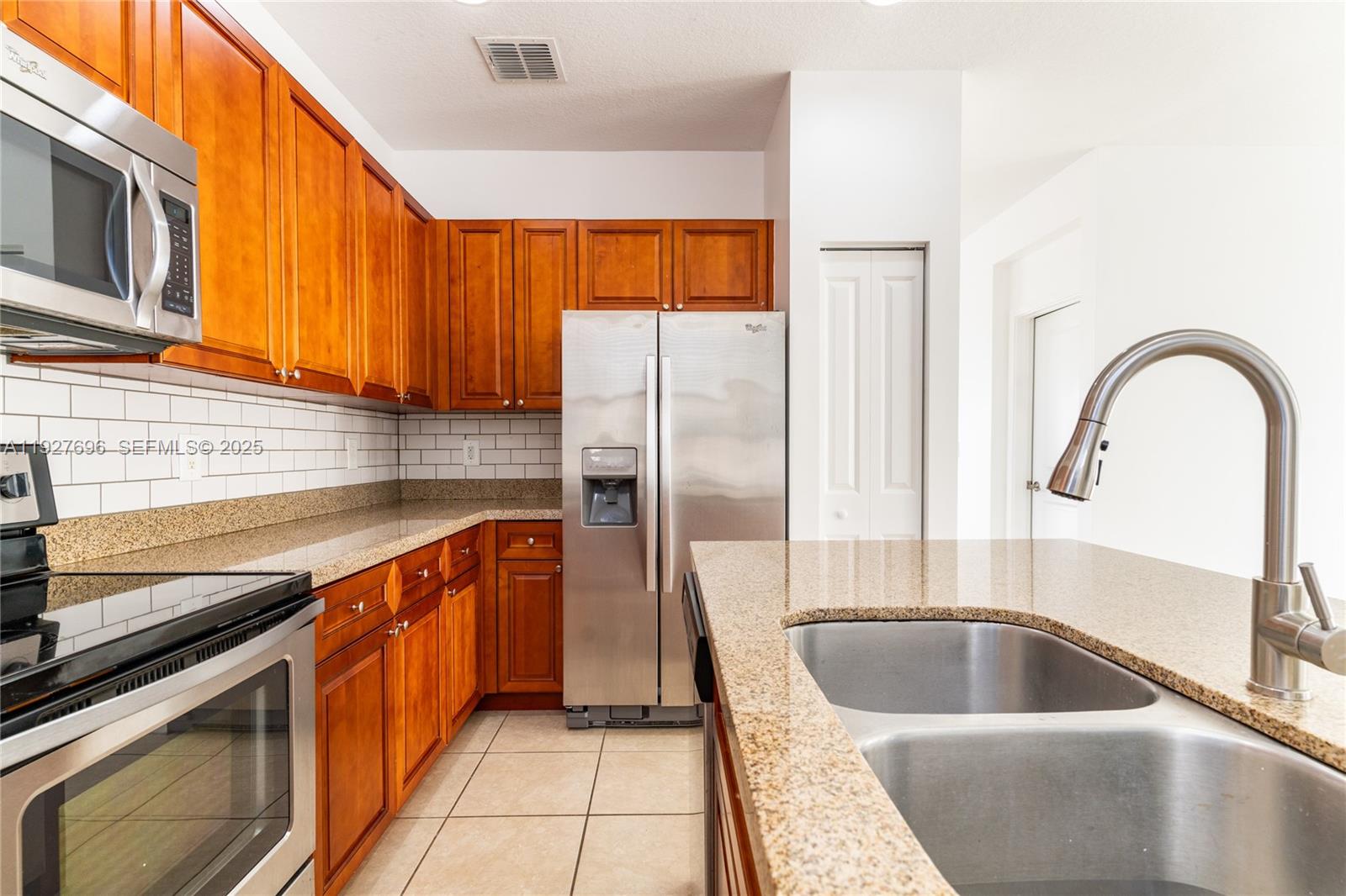 4638 Northwest 59th Street Tamarac, FL 33319 - Photo 3 of 34 a kitchen with granite countertop a sink and a stove top oven