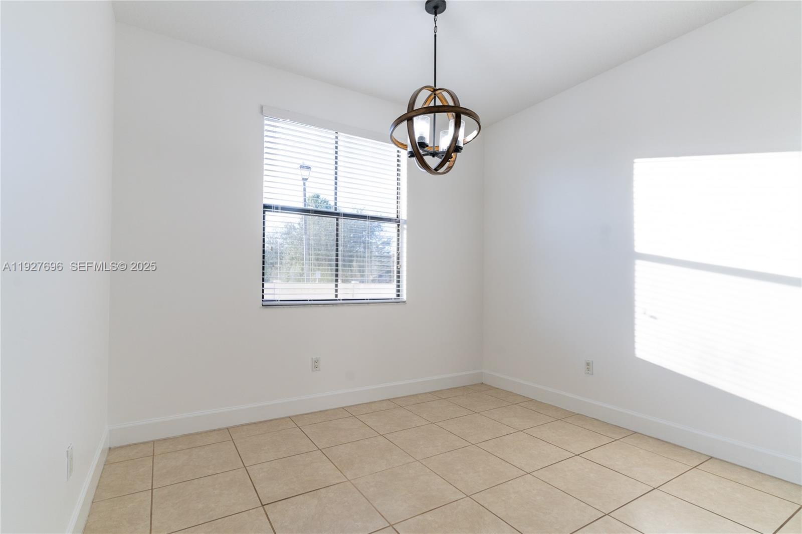 4638 Northwest 59th Street Tamarac, FL 33319 - Photo 9 of 34 an empty room with windows and chandelier