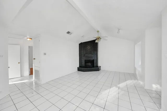 an empty room with fireplace and windows