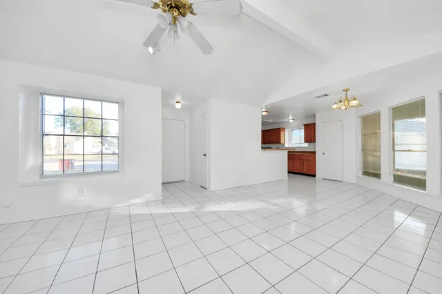 an empty room with chandelier and windows