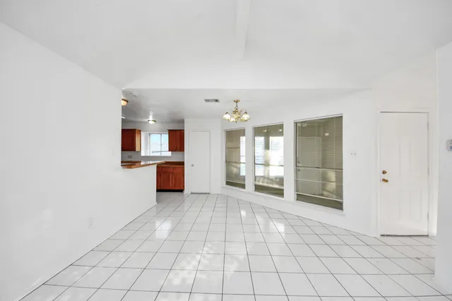 a view of a kitchen with cabinet and an empty room