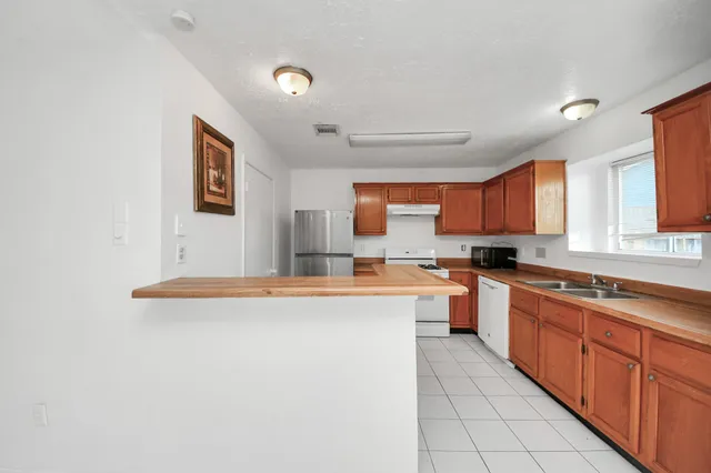 a large kitchen with stainless steel appliances granite countertop a sink and cabinets
