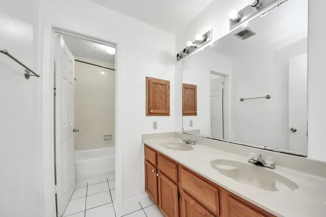 a bathroom with a double vanity sink mirror and shower