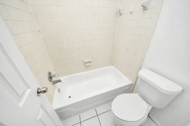 a white toilet sitting next to a bath tub