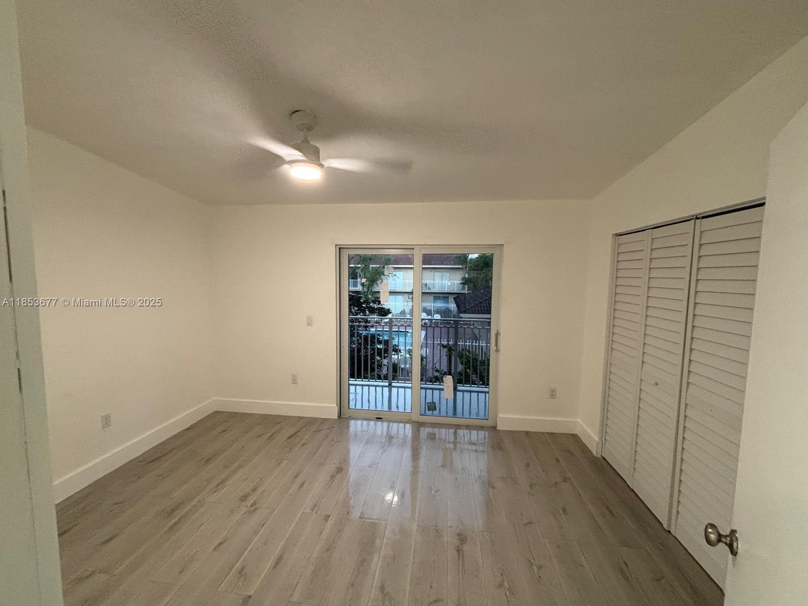6886 Northwest 166th Terrace, Unit 1004 Miami Lakes, FL 33014 - Photo 15 of 27 wooden floor in an empty room with a window