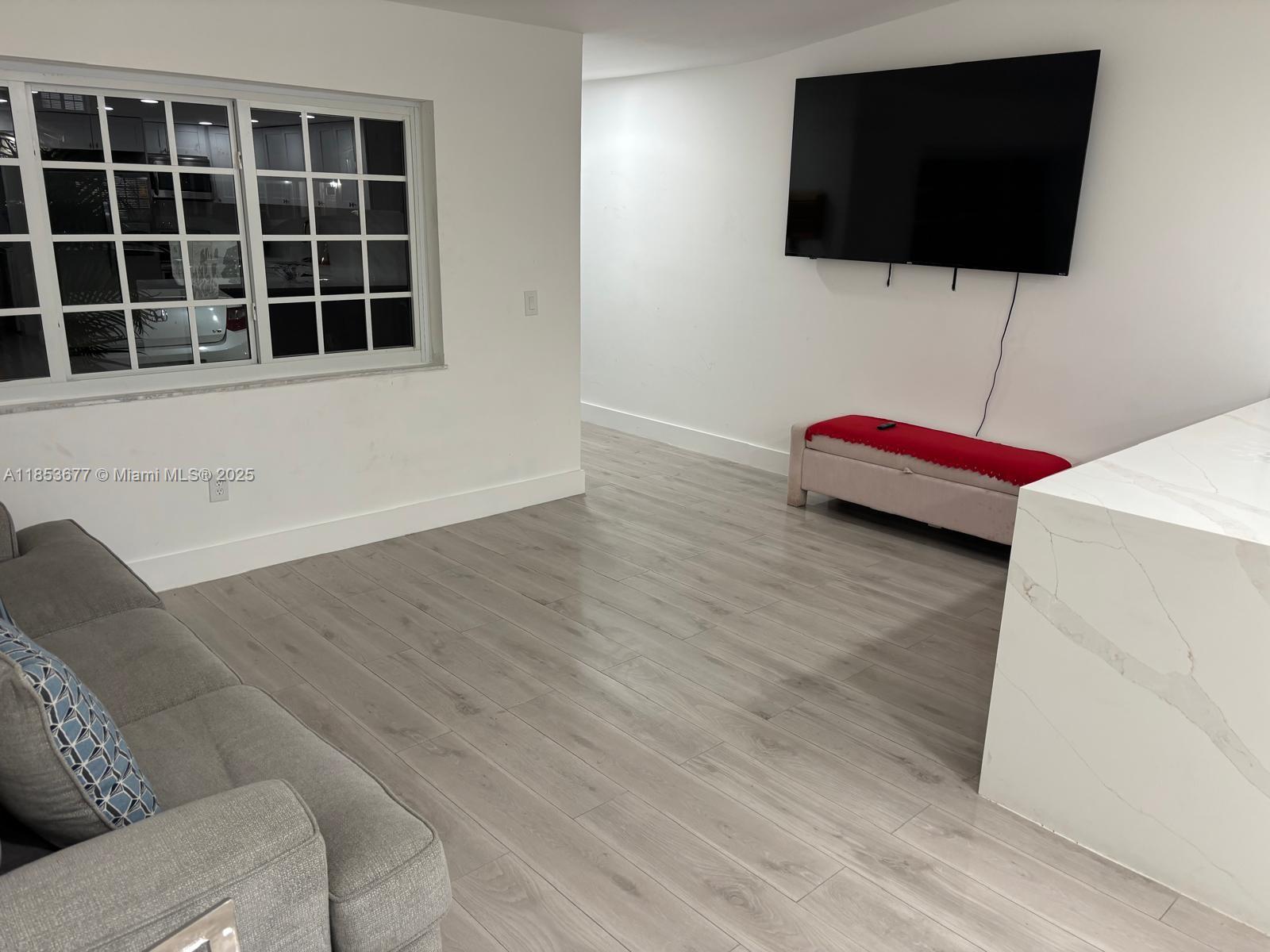 6886 Northwest 166th Terrace, Unit 1004 Miami Lakes, FL 33014 - Photo 21 of 27 a living room with a flat screen tv and a wall painting