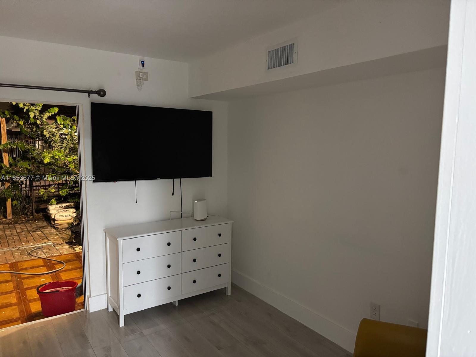 6886 Northwest 166th Terrace, Unit 1004 Miami Lakes, FL 33014 - Photo 25 of 27 a view of room with wooden floor and flat screen tv