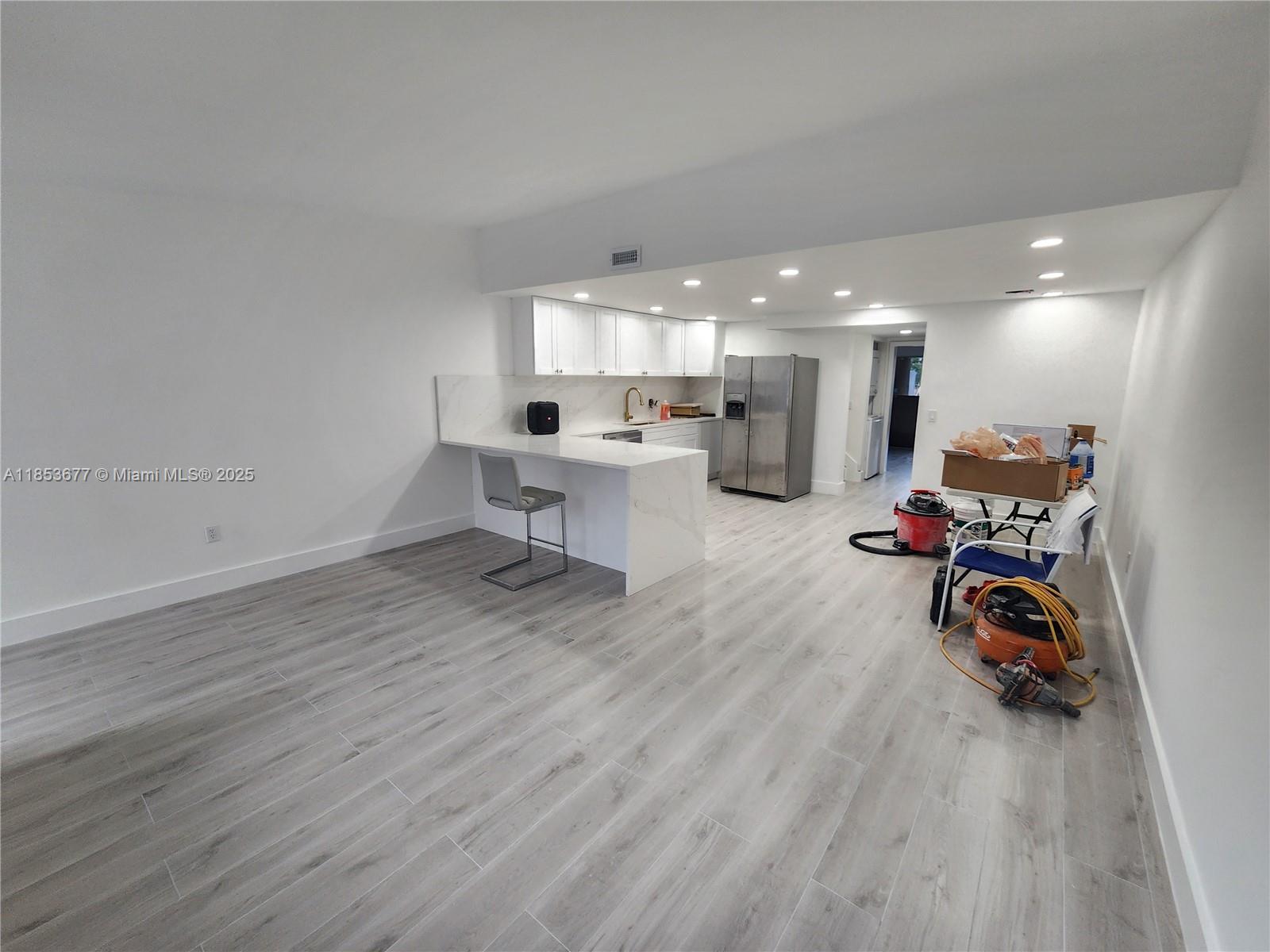 6886 Northwest 166th Terrace, Unit 1004 Miami Lakes, FL 33014 - Photo 3 of 27 a view of a room with wooden floor and furniture