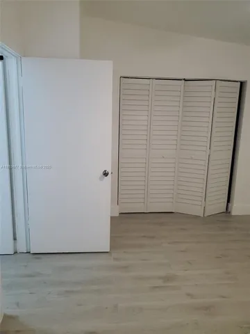an entryway with wooden floor and white walls