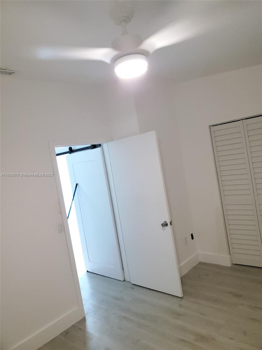 6886 Northwest 166th Terrace, Unit 1004 Miami Lakes, FL 33014 - Photo 6 of 27 an entryway with wooden floor and white walls